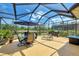 Outdoor dining and lounging area on a screened lanai with scenic pond views at 11437 Dancing River Dr, Venice, FL 34292