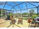 Enjoy the outdoors with a screened lanai featuring seating, dining, and tranquil pond views at 11437 Dancing River Dr, Venice, FL 34292