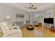 Comfortable living room with tray ceiling, modern decor, and hardwood floors at 11437 Dancing River Dr, Venice, FL 34292