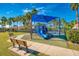 Community playground featuring a blue play structure with slides and climbing features at 11437 Dancing River Dr, Venice, FL 34292