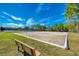 Exterior shot of a community volleyball court with a view of a park bench in the foreground at 11437 Dancing River Dr, Venice, FL 34292