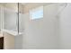 Bright white tiled shower with glass partition and window providing natural light at 11455 Fort Lauderdale Pl, Venice, FL 34293