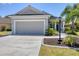 Attractive home featuring a neutral color scheme, attached two-car garage, and a well-maintained front yard with plants at 11455 Fort Lauderdale Pl, Venice, FL 34293