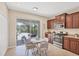Open kitchen with dark wood cabinets, granite countertops, and access to an outdoor screened living space at 11455 Fort Lauderdale Pl, Venice, FL 34293