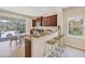Kitchen featuring granite countertops, dark wood cabinets, and a bar area with seating overlooking outdoor space at 11455 Fort Lauderdale Pl, Venice, FL 34293