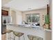Kitchen bar area with granite countertops, seating, and a view of the outdoor living space with a pool at 11455 Fort Lauderdale Pl, Venice, FL 34293