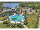 Overhead view of a community splash pad with blue and yellow accents, surrounded by palm trees and lush landscaping at 11455 Fort Lauderdale Pl, Venice, FL 34293