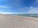 Expansive sandy beach with gentle waves and a clear blue sky, perfect for a relaxing day at 1150 Tarpon Center Dr # 3G 307, Venice, FL 34285
