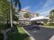 Welcoming building entrance featuring a porte cochere, lush landscaping and ample parking at 1150 Tarpon Center Dr # 3G 307, Venice, FL 34285
