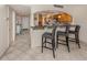 Modern kitchen bar with barstool seating, view of kitchen cabinetry, and access to the hallway at 1150 Tarpon Center Dr # 3G 307, Venice, FL 34285