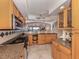 Spacious kitchen area with wooden cabinetry, modern appliances, and open access to the living room at 1150 Tarpon Center Dr # 3G 307, Venice, FL 34285