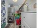 Compact laundry area features stacked washer/dryer, storage and closet with beach chairs at 1150 Tarpon Center Dr # 3G 307, Venice, FL 34285