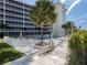 Scenic view of the pool area with lounge chairs, palm trees, and a glimpse of the ocean at 1150 Tarpon Center Dr # 3G 307, Venice, FL 34285