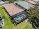 Aerial view of backyard of house featuring screened in pool and lake at 11610 Dancing River Dr, Venice, FL 34292