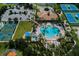 An aerial of a community pool, basketball court and tennis courts with lush landscaping and seating at 11610 Dancing River Dr, Venice, FL 34292