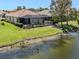Waterfront backyard with screened lanai and pool overlooking lush landscaping and a peaceful lake at 11610 Dancing River Dr, Venice, FL 34292