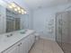 Well-lit bathroom featuring a double vanity, shower, and refreshing, light blue paint at 11610 Dancing River Dr, Venice, FL 34292