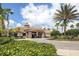 Clubhouse exterior showcasing elegant architecture, lush landscaping, and welcoming entrance at 11610 Dancing River Dr, Venice, FL 34292