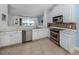 Modern kitchen with stainless steel appliances, white cabinetry, and tile flooring at 11610 Dancing River Dr, Venice, FL 34292