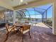 View of brick-paved patio with view through screen enclosure to lake and pool with spa at 11610 Dancing River Dr, Venice, FL 34292