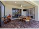 Covered patio with brick pavers, ceiling fan, television and view through to backyard and pond at 11610 Dancing River Dr, Venice, FL 34292