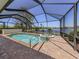 Screened pool with an attached spa overlooking a tranquil lake at 11610 Dancing River Dr, Venice, FL 34292