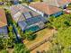 Aerial view of a backyard with a screened pool, surrounded by lush greenery and a fence at 11711 Alessandro Ln, Venice, FL 34293