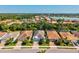 Birds eye view of a neighborhood featuring a beautiful home, lush trees, and a serene lake at 11711 Alessandro Ln, Venice, FL 34293