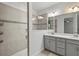 Modern bathroom features a glass shower and a double sink vanity with neutral color tones and backsplash accents at 11711 Alessandro Ln, Venice, FL 34293