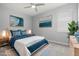 Stylishly staged bedroom with tranquil blue accents, decorative art, and ample natural light from the window at 11711 Alessandro Ln, Venice, FL 34293