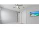 Bright bedroom features plush carpeting, ceiling fan, and a wall-mounted television for comfortable living at 11711 Alessandro Ln, Venice, FL 34293