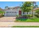 Charming home with a brick driveway, well manicured landscaping, and a cozy front porch at 11711 Alessandro Ln, Venice, FL 34293