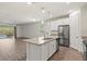 Open concept kitchen features granite countertops, a stainless refrigerator, and island sink at 11711 Alessandro Ln, Venice, FL 34293