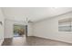 Empty room, with tile flooring, leading to a screened lanai and swimming pool at 11711 Alessandro Ln, Venice, FL 34293