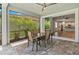 Relaxing screened-in patio with tile flooring, ceiling fan, and a view of the tropical landscaping at 11711 Alessandro Ln, Venice, FL 34293