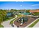 Community playground with lake views, a tennis court, and lush tropical landscaping at 11711 Alessandro Ln, Venice, FL 34293