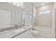 Bright bathroom featuring granite countertops, a sleek, white vanity, and a shower-tub combo with tiled walls at 12199 Xavier Ave, Port Charlotte, FL 33981