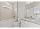 Well-lit bathroom with a granite countertop vanity and a shower-tub combo with light beige tiles at 12199 Xavier Ave, Port Charlotte, FL 33981