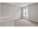 Well-lit bedroom featuring neutral carpet, a single bed with pink bedding and a large window with sheer white curtains at 12199 Xavier Ave, Port Charlotte, FL 33981