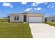 Charming single-Gathering home featuring a two-car garage and a well-maintained front lawn at 12199 Xavier Ave, Port Charlotte, FL 33981