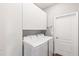 Laundry room with overhead cabinets, washer and dryer, and an ironing board, for convenience and functionality at 12199 Xavier Ave, Port Charlotte, FL 33981