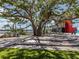 Inviting community space featuring a large shade tree, wood deck, and grassy area on the lake at 12515 Felice Dr, Venice, FL 34293