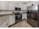 Well-lit kitchen features stainless steel appliances, granite counters, and plenty of white cabinetry at 12515 Felice Dr, Venice, FL 34293