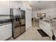 Clean kitchen with stainless steel appliances, granite countertops, and white cabinets, open to the dining room at 12515 Felice Dr, Venice, FL 34293