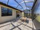 Enclosed patio featuring pavers, outdoor dining area, grill, and view of the backyard at 12515 Felice Dr, Venice, FL 34293