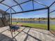 Enclosed patio with table and chairs overlooking a serene pond, perfect for outdoor relaxation at 12515 Felice Dr, Venice, FL 34293