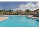 A large community pool is surrounded by palm trees and lounge chairs with orange umbrellas at 12515 Felice Dr, Venice, FL 34293