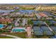 Panoramic aerial view of a community with multiple lakes, tennis courts, and a swimming pool surrounded by lush landscaping at 12897 Oriago St, Venice, FL 34293