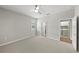 Bedroom with carpeted floors, ceiling fan, and view of laundry room and hallway doors at 12897 Oriago St, Venice, FL 34293