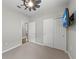 Bedroom features neutral walls, ceiling fan, a mounted TV and sliding closet doors at 12897 Oriago St, Venice, FL 34293